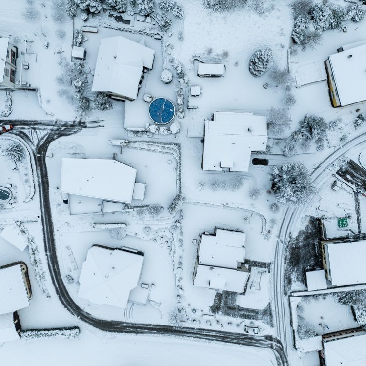 Aerial view of town with snow covered houses. Roof tops with sno